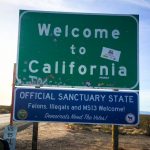 Fake but real-looking California sign posted below a "Welcome to California" sign that reads "Official Sanctuary State, Felons, Illegals and MS13 Welcome! Democrats Need the Votes!"
