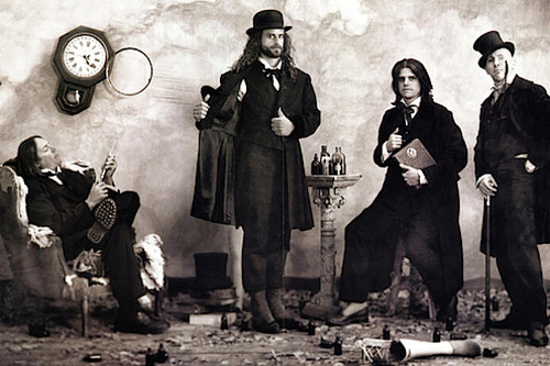 Group photo of the band Tool wearing old-fashioned clothes and striking poses. [Formatted]